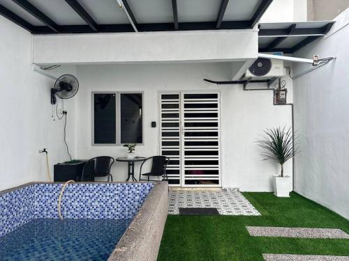 a house with a swimming pool in a yard at Homestay Rumah Puteh Melaka in Kampong Bukit Katil
