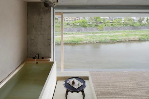 a room with a large window looking out at a river at Kamohan in Kyoto