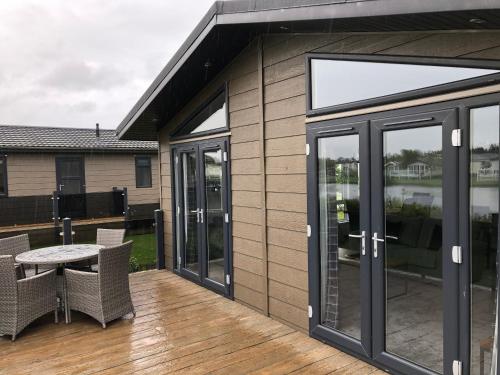 a patio with glass doors and a table on a deck at Oakwood Lodge in Cheswick