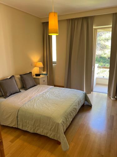 um quarto com uma cama grande e uma janela em Dionisos luxury apartment em Atenas