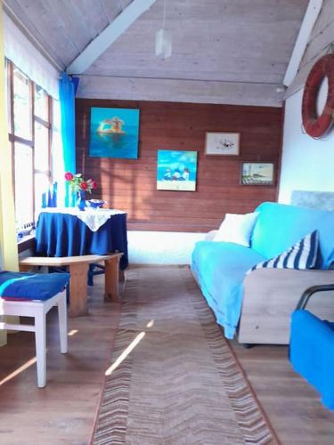 a living room with a couch and a table at Pie Garozas in Lapmežciems