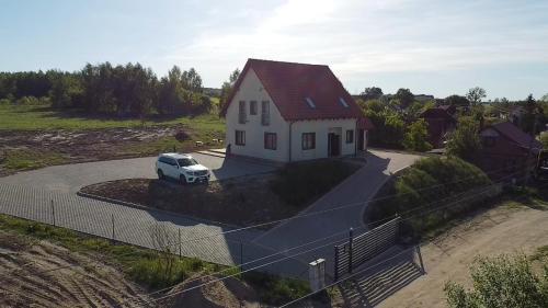 uma casa branca com um carro estacionado na garagem em Pęglity jezioro em Gietrzwałd