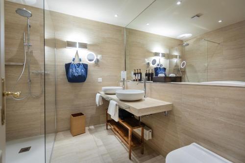 un bagno con due lavandini e una doccia in vetro di Villa Favorita - Parkhotel Delta ad Ascona