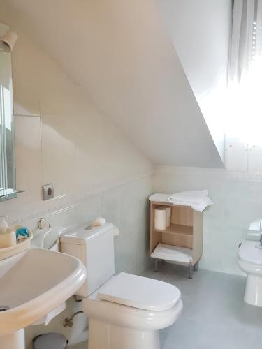 La salle de bains blanche est pourvue de toilettes et d'un lavabo. dans l'établissement 3 bedrooms apartement with furnished terrace and wifi at Astorga, à Astorga