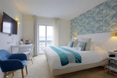 Schlafzimmer mit einem Bett, einem Schreibtisch und einem TV in der Unterkunft Hotel Le Relais Saint-Jacques in Saint-Jean-de-Luz