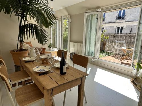 une salle à manger avec une table en bois et une fenêtre dans l'établissement L'appartement Dagorno, à Paris