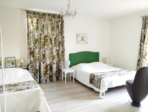- une chambre avec 2 lits et un rideau vert dans l'établissement Les Malvaux, à Huriel