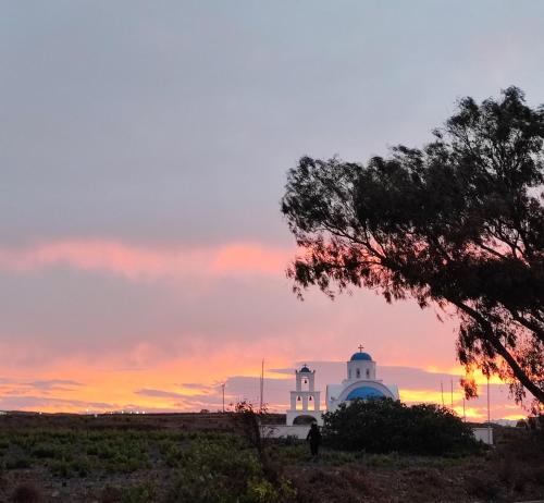 a white building with a sunset in the background at Agapi Villas in Karterados