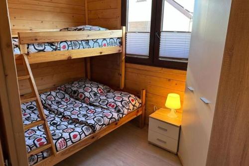 a bedroom with two bunk beds and a lamp at Ośrodek Wczasowy Amelia in Jarosławiec
