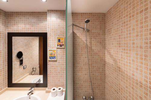 a bathroom with a shower with a sink and a mirror at Apartamento moderno bh aspen atico con vistas in El Tarter