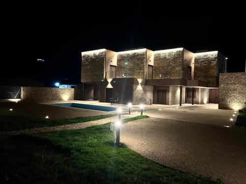 un gran edificio con luces delante de él por la noche en Reserva Benazaire, en Herrera del Duque
