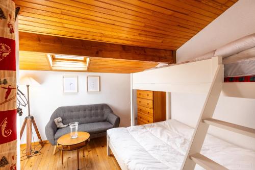 - une chambre avec des lits superposés et un canapé dans l'établissement Cosy Wood - Appt vue lac et montagne, aux Angles