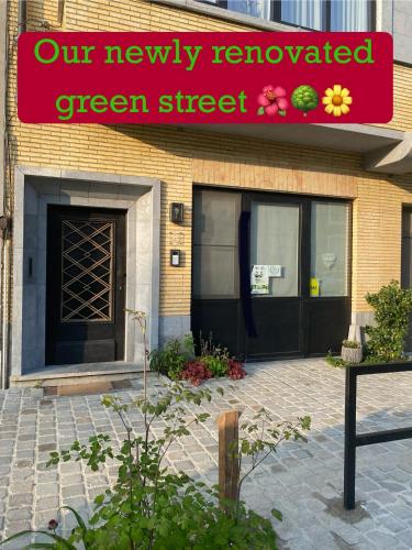 a building with a green street sign and a black door at B&B Royal Swans in Bruges
