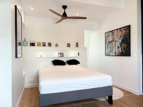 a bedroom with a bed with a ceiling fan at Maison rénovée 4 personnes - Prox Lille in Marquette-lès-Lille