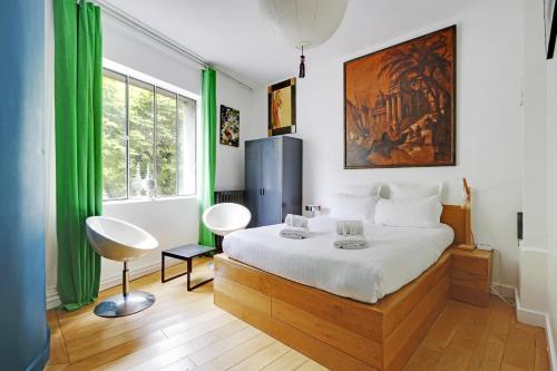 une chambre avec un lit et une grande fenêtre dans l'établissement Pick A Flat's Townhouse in Montparnasse - Boulevard du Montparnasse, à Paris