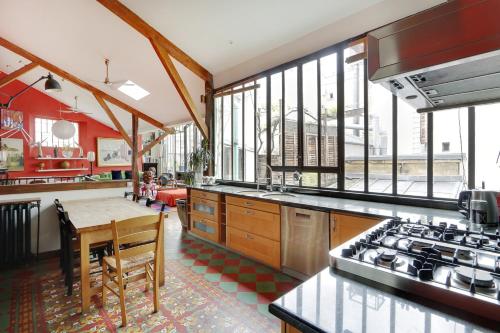 - une cuisine avec une table et quelques fenêtres dans l'établissement Pick A Flat's Townhouse in Montparnasse - Boulevard du Montparnasse, à Paris