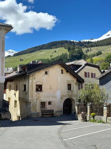 a building with a bench in front of a mountain at Chasa Veglia in Sent