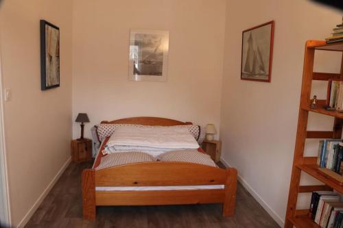 a bedroom with a wooden bed in a room at Maison Dinannaise -Les Roses- in Dinan