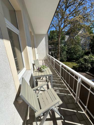 two white chairs and a table on a balcony at Victoria Apartment in Chemnitz