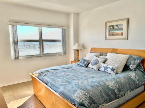 - une chambre avec un lit avec une couette bleue et 2 fenêtres dans l'établissement Regatta C610, à Clearwater Beach