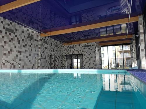 a large swimming pool with blue water in a building at Apartament Sailor by HolidaySun in Sianozety
