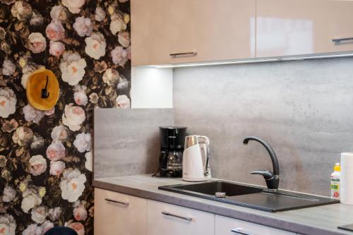 a kitchen with a sink and a floral wallpaper at Apartament Sailor by HolidaySun in Sianozety