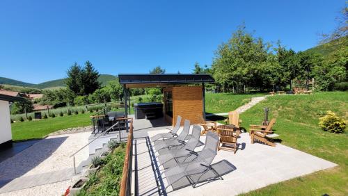 a covered patio with chairs and a grill at Somos Lux Vendégház in Somoskőújfalu