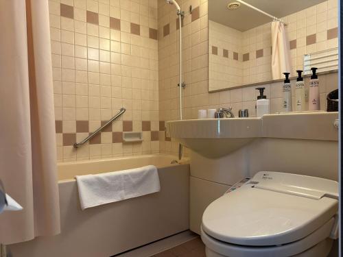 La salle de bains est pourvue de toilettes, d'un lavabo et d'une baignoire. dans l'établissement Kyoto Yamashina Hotel Sanraku, à Kyoto