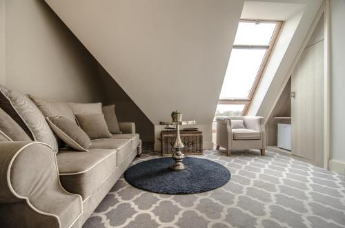 a living room with a couch and a chair at Willa Legenda Hotel Adults Only in Mielno