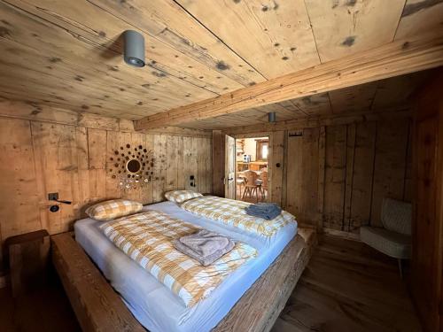 a large bed in a room with a wooden ceiling at Chasa Veglia in Sent