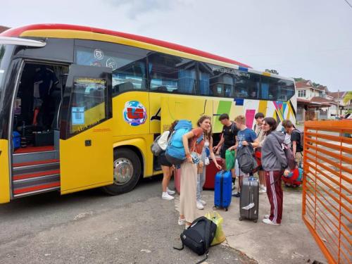 a group of people standing in front of a yellow bus at Greenleaf Angsana Homestay in Jerantut