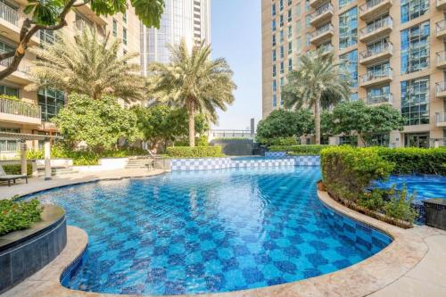une grande piscine bleue avec des palmiers et des bâtiments dans l'établissement Trinity Holiday Homes - Standpoint Tower Downtown, à Dubaï
