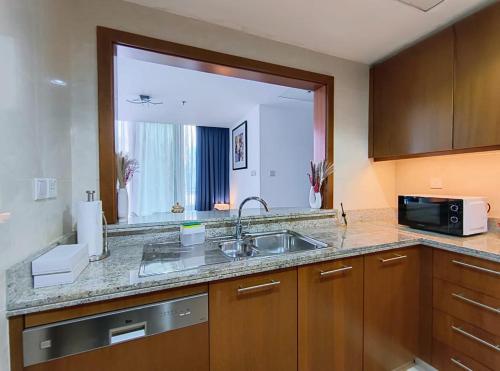 - une cuisine avec un évier et un grand miroir dans l'établissement Trinity Holiday Homes - Standpoint Tower Downtown, à Dubaï