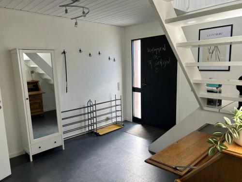 a hallway with a staircase and a black door at Kokhaven 23 in Rødekro