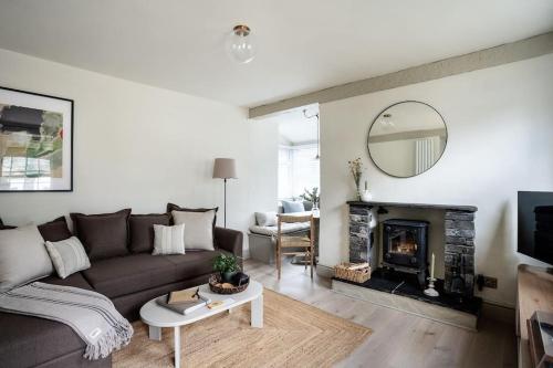 un soggiorno con divano e camino di Drakes Cottage a Cartmel