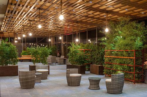 a patio with tables and chairs and potted plants at Corten Hotel in Santa Maria di Licodia