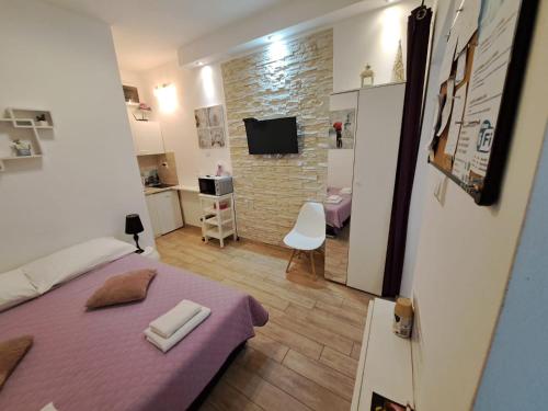 Un pequeño dormitorio con una cama morada en una habitación en Studio Apartment Legcevic en Kaštela