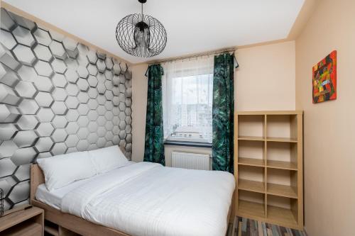 克拉科夫的住宿－Piastów Standard Apartment，一间卧室设有一张床和一个窗口