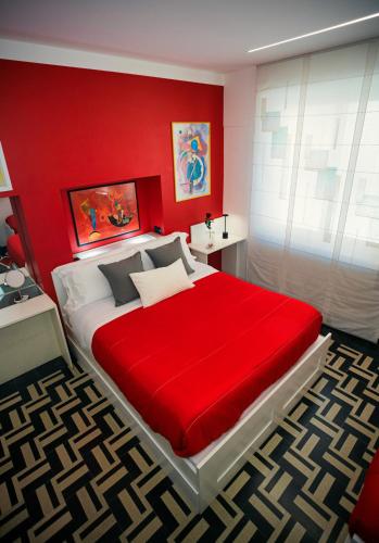 a red bedroom with a large bed with a red wall at B&B degli Artisti in Palmi