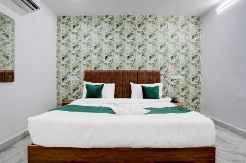 PrayagrajにあるHotel Garden Viewのベッドルーム1室(緑と白の枕が備わる大型ベッド1台付)