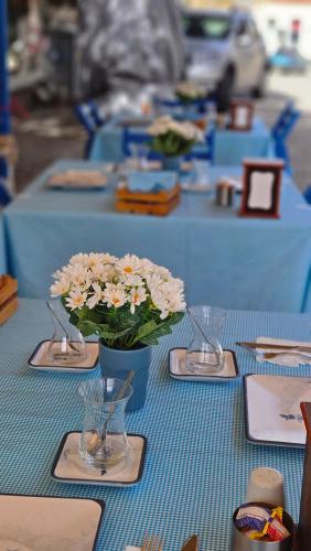 a row of blue tables with a vase of flowers at Ada Kalimera Bozcaada in Bozcaada