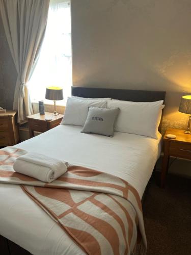 a bedroom with a large white bed with two pillows at Fairlawn House in Amesbury