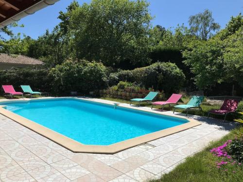 - une piscine dans une cour avec des chaises dans l'établissement Maison Villa Bassin Arcachon 170m2 avec piscine, à Gujan-Mestras