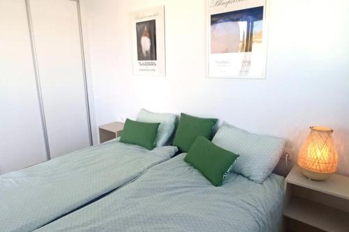 a bedroom with a bed with green pillows at Grande corner villa in Isla Plana by the sea in Isla Plana