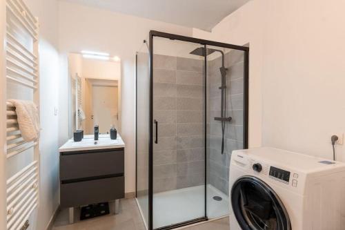une salle de bain avec douche et machine à laver dans l'établissement Location T3 traversant lumineux, à Marseille