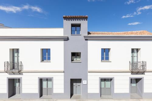 a white building with a blue sky in the background at Domu Qirat - Authentic Rooms & Terraces in Tortolì