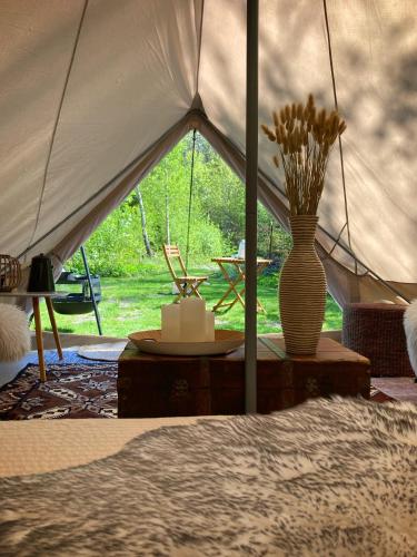 a tent with a vase of flowers on a table at Glamping Grindhuset in Helgeroa