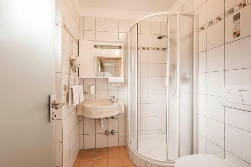 La salle de bains est pourvue d'une douche et d'un lavabo. dans l'établissement Hotel Karin, à Tirolo