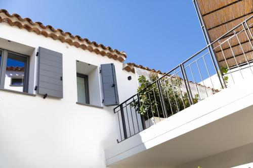 a white building with windows and a balcony at Domu Qirat - Authentic Rooms & Terraces in Tortolì