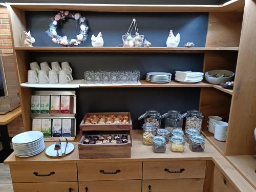 a cabinet filled with plates and bowls of food at Hotel Faraon in Celje